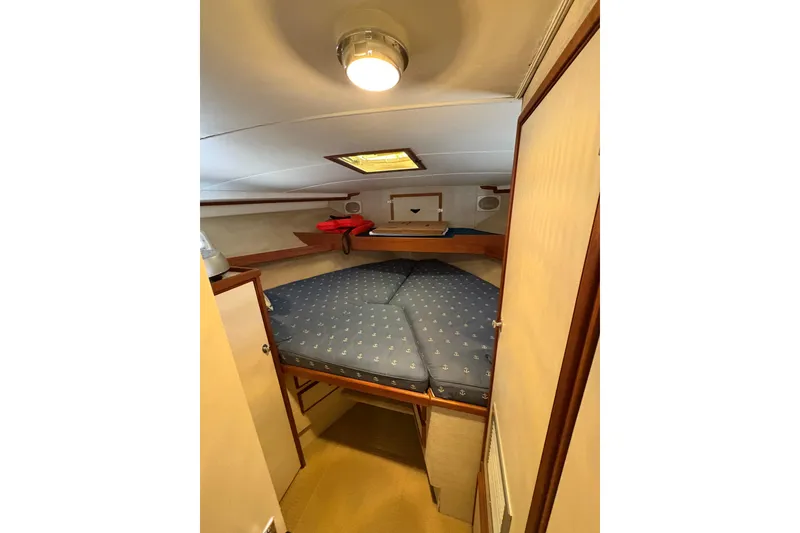 Slide: The Image of Cozy cabin interior of 1987 Bertram 46.6 yacht with blue bedding and wooden accents. - 41