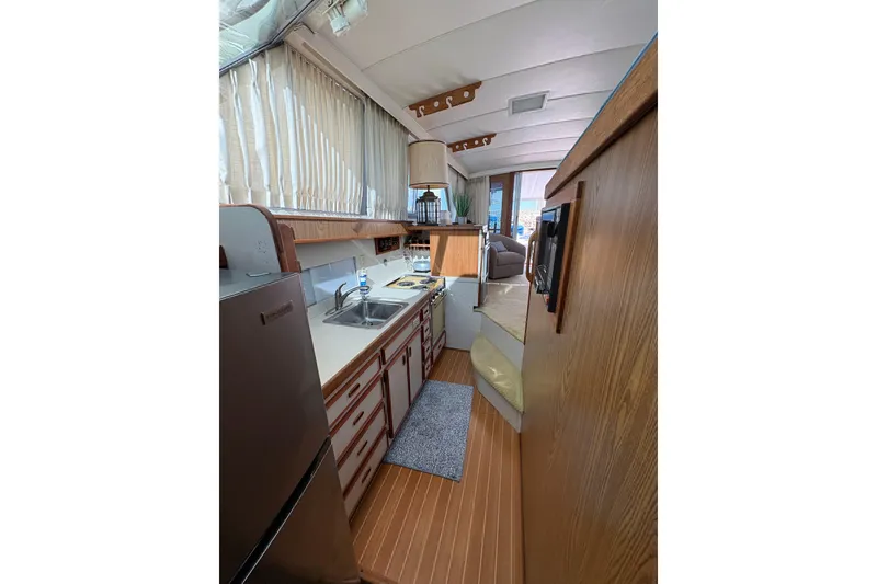 Slide: The Image of Interior of 1987 Bertram 46.6 yacht, featuring kitchen area with wood accents and appliances. - 44