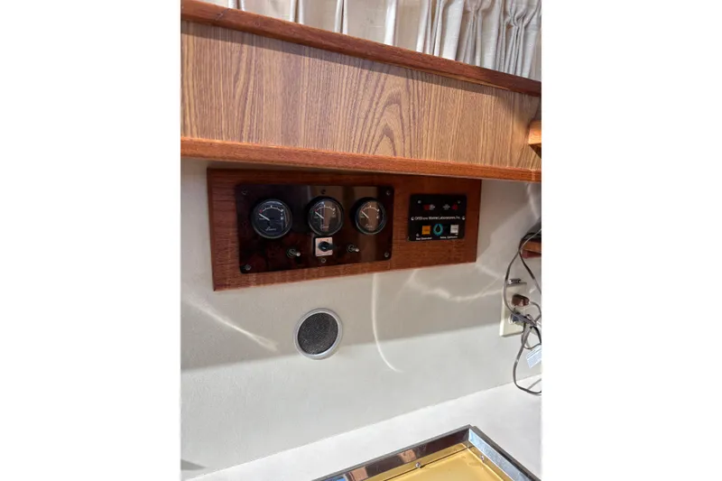 Slide: The Image of Control panel on a 1987 Bertram 46.6 yacht with wood finish and gauges. - 46