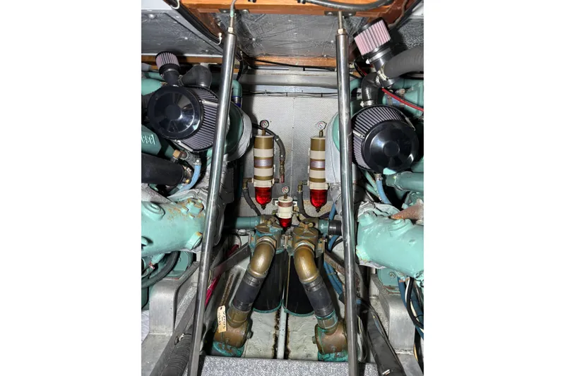 Slide: The Image of Engine room of a 1987 Bertram 46.6 yacht, showcasing mechanical components and filters. - 49