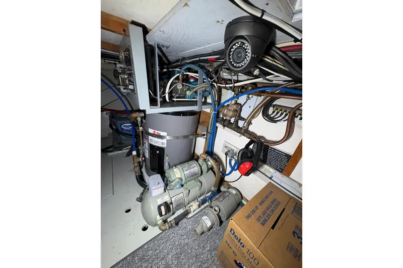 Slide: The Image of Engine room of a 1987 Bertram 46.6 yacht with mechanical equipment and wiring. - 52