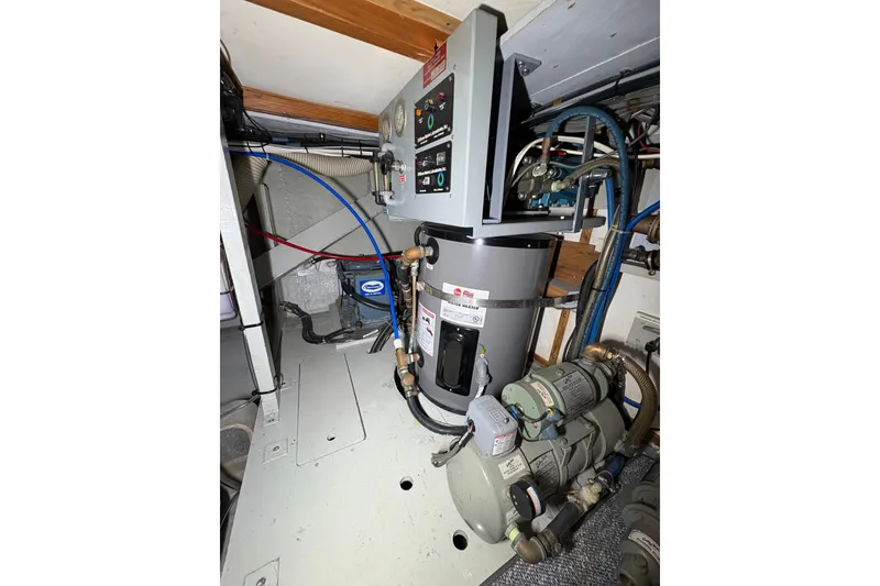 Slide: The Image of Engine room of 1987 Bertram 46.6 yacht with water heater and machinery. - 53
