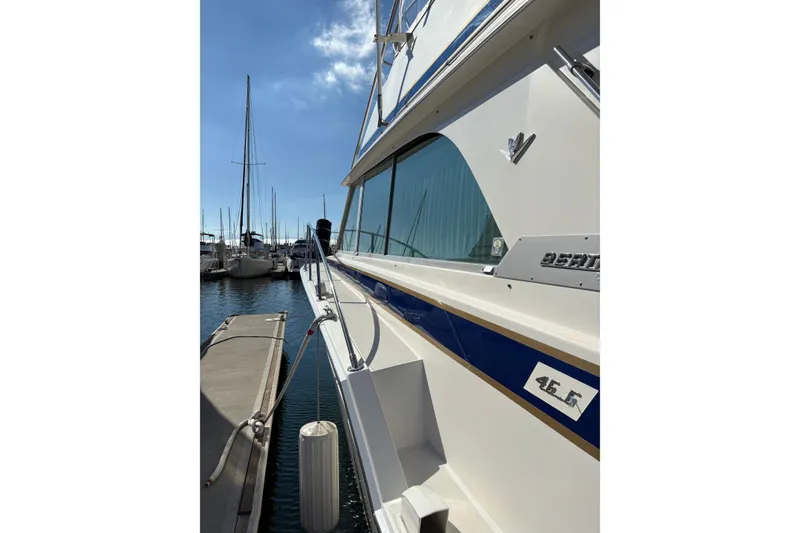 Slide: The Image of 1987 Bertram 46.6 yacht docked at marina under clear blue sky. - 8