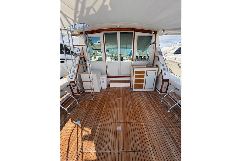 Slide: The Image of 1987 Bertram 46.6 yacht deck with wooden flooring and ladder. - 9