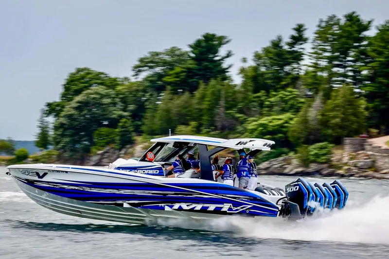 The Image of 2024 MTI V42 boat on clear blue water with city skyline background. - 0