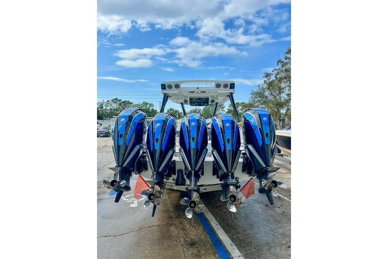 Slide: The Image of Four powerful outboard motors on a 2024 MTI V42 boat, with a cityscape backdrop. - 13