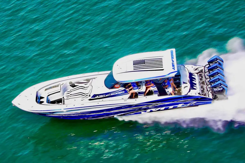 Slide: The Image of 2024 MTI V42 boat on water with city skyline in background. - 2