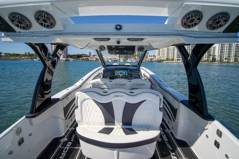 Slide: The Image of 2024 MTI V42 luxury boat interior with sleek seating and advanced dashboard on calm water. - 20