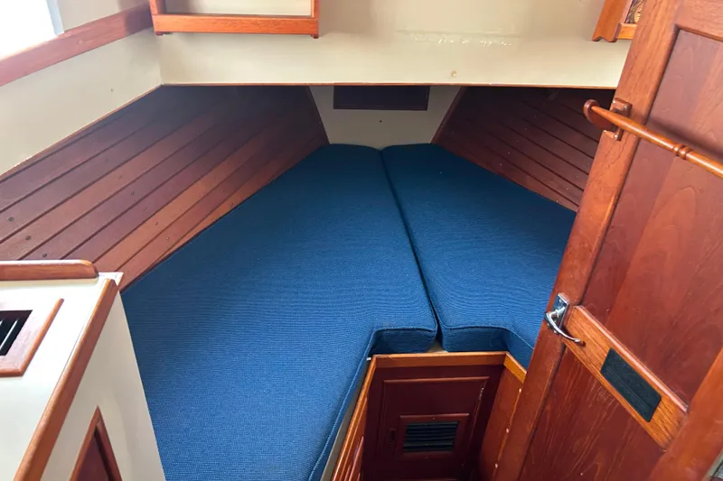 Slide: The Image of Interior cabin of 1980 Grand Banks 42 Classic with blue cushions and wooden paneling. - 10