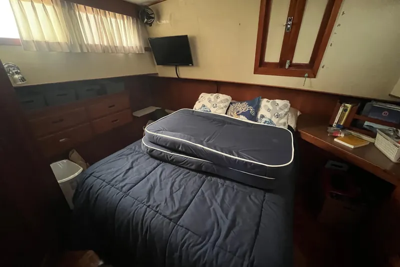 Slide: The Image of Cozy bedroom in 1980 Grand Banks 42 Classic yacht with bed, pillows, and wooden cabinetry. - 13