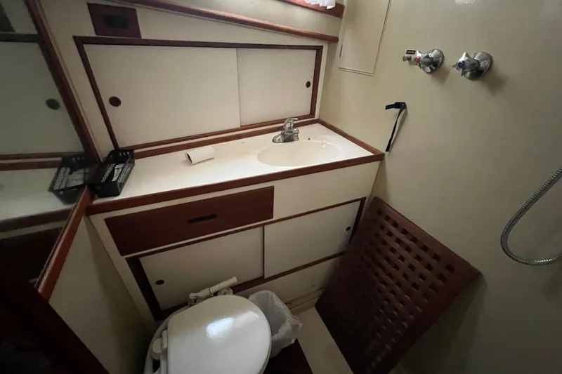 Slide: The Image of 1980 Grand Banks 42 Classic yacht bathroom with sink, toilet, and storage cabinets. - 17