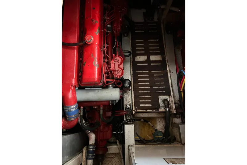 Slide: The Image of Engine room of a 1980 Grand Banks 42 Classic, featuring a red engine and mechanical components. - 25