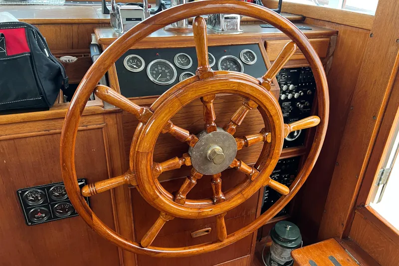 Slide: The Image of Wooden helm of a 1980 Grand Banks 42 Classic yacht, showcasing vintage nautical controls. - 8