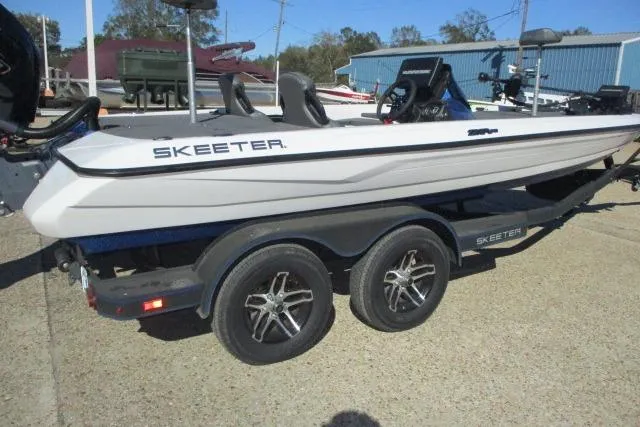 Slide: The Image of 2024 Skeeter ZXR19 boat on trailer, parked outdoors. - 2