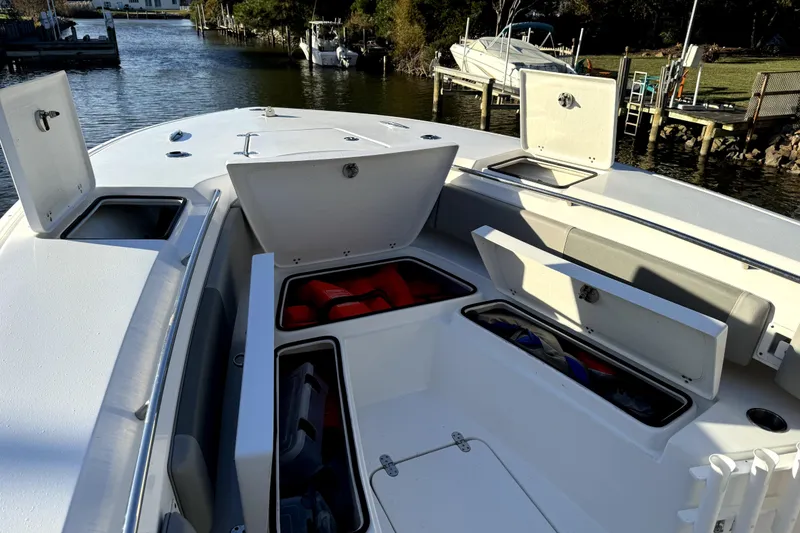 Slide: The Image of 2021 Cape Horn 32 XS boat with open storage compartments on a calm waterway. - 3