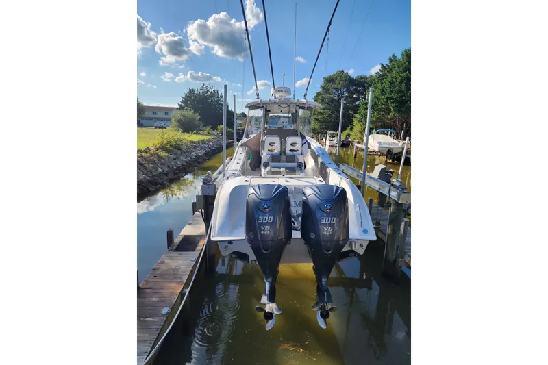 Slide: The Image of 2021 Cape Horn 32 XS boat with dual 300 V6 engines docked in a serene canal. - 4