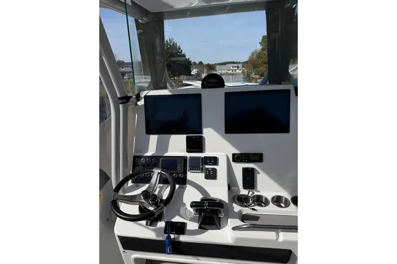 Slide: The Image of 2021 Cape Horn 32 XS boat dashboard with dual screens and steering wheel. - 7