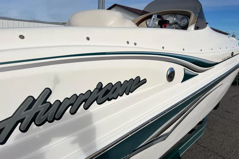 Slide: The Image of 2006 Hurricane FunDeck GS 194 OB boat, white with green accents, docked outdoors. - 15