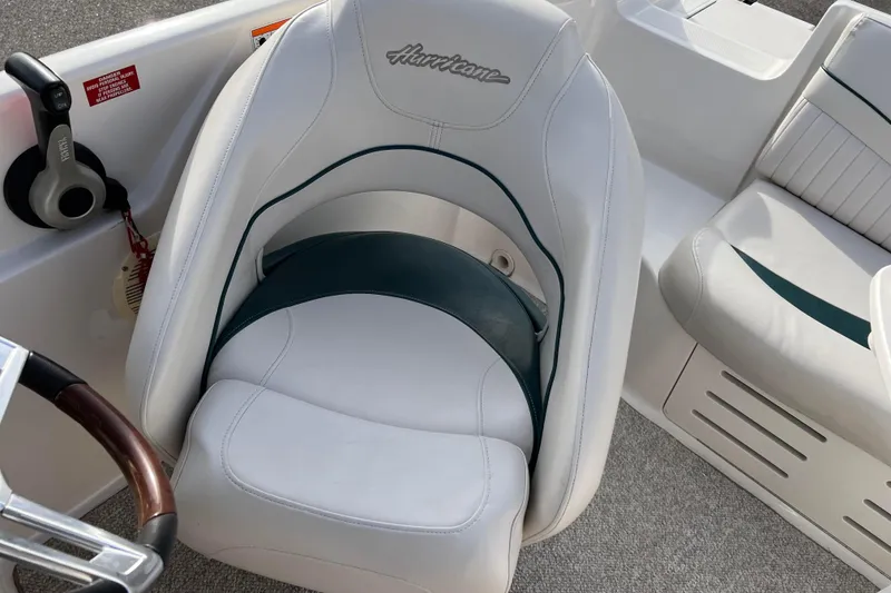 Slide: The Image of 2006 Hurricane FunDeck GS 194 OB boat seat and steering area, featuring white upholstery. - 36
