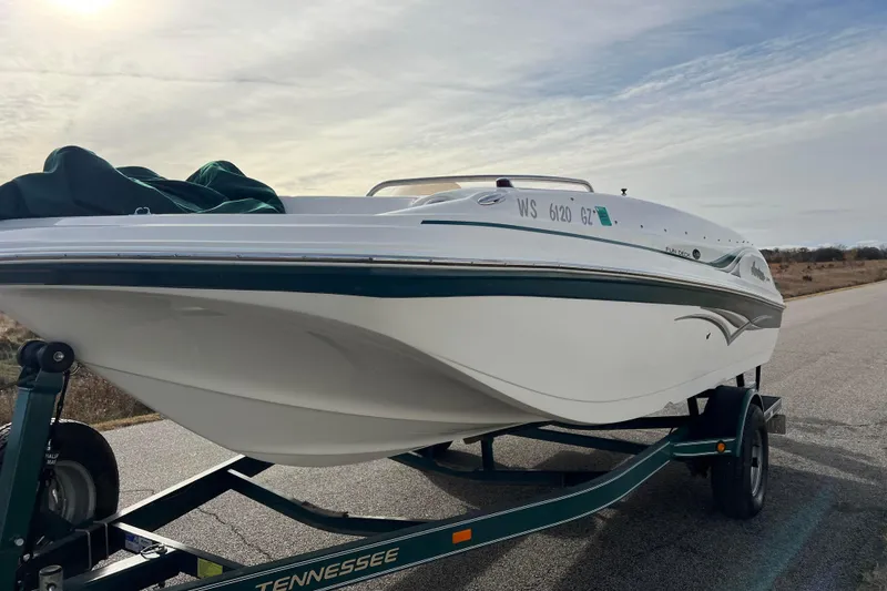 Slide: The Image of 2006 Hurricane FunDeck GS 194 OB boat on trailer, parked on a road under cloudy sky. - 7