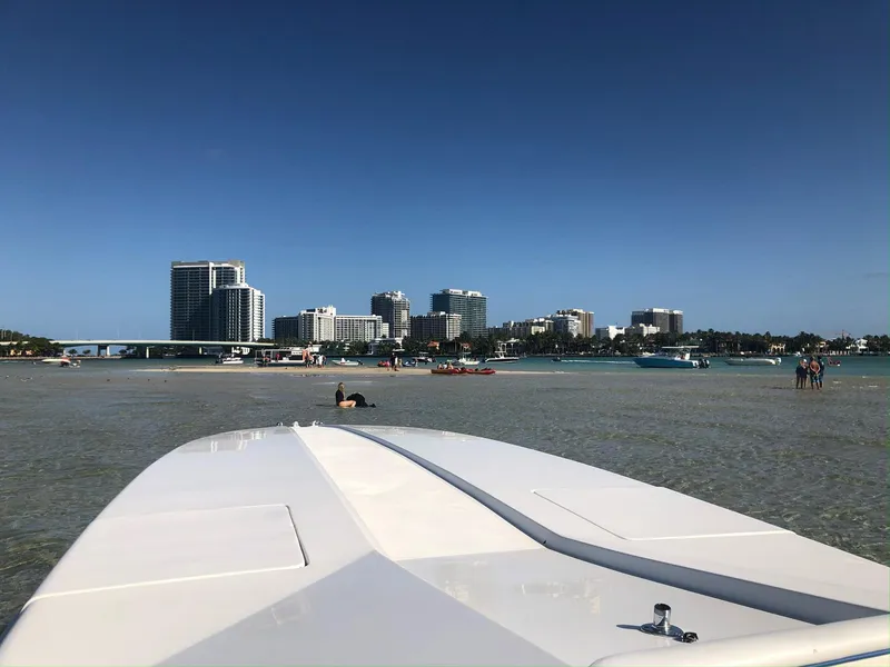 Slide: The Image of 1992 Cigarette 35 Cafe Racer boat in shallow water with city skyline. - 5