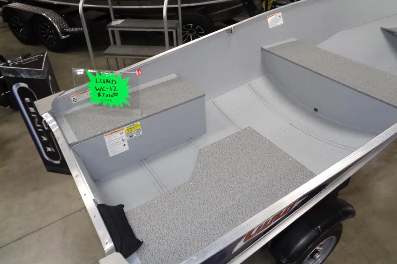 Slide: The Image of 2026 Lund WC-12 boat interior with gray seating and price tag displayed. - 4