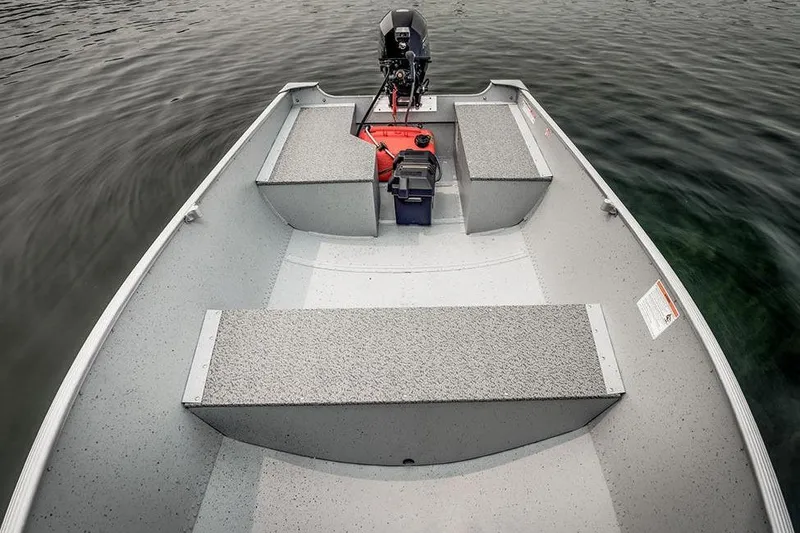 Slide: The Image of Manufacturer Provided Image: 2026 Lund WC-12 boat interior with motor, benches, and storage on calm water. - 8