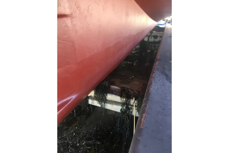 Slide: The Image of Red hull of 2000 Calvin Beal COI PASSENGER boat in dry dock. - 13