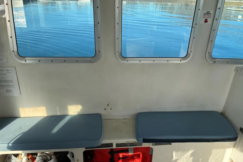 Slide: The Image of Interior of a 2000 Calvin Beal COI Passenger boat with blue cushioned seats. - 35