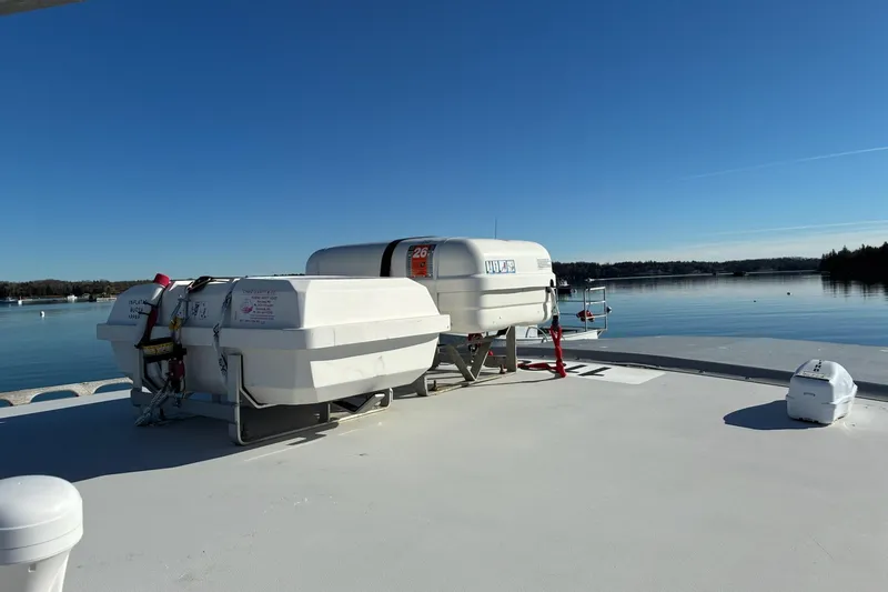 Slide: The Image of Calvin Beal COI PASSENGER boat deck with life rafts, calm water, clear sky. - 5