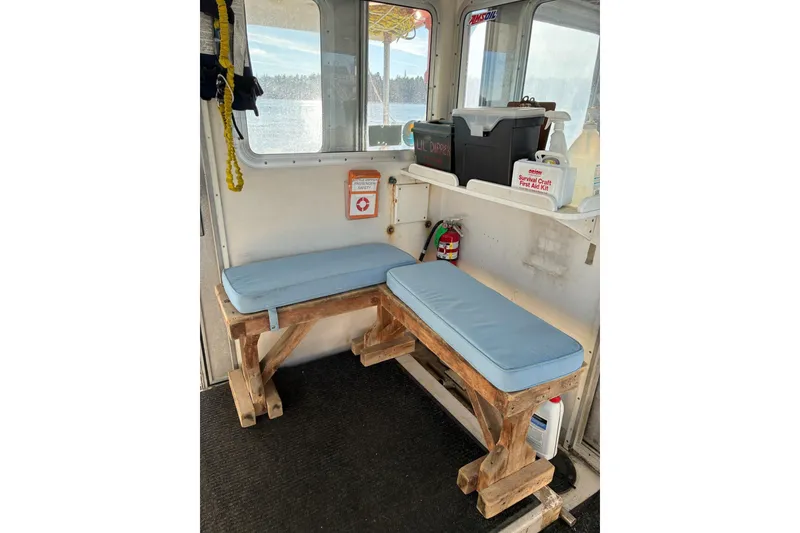 Slide: The Image of Interior of 2000 Calvin Beal COI Passenger boat with wooden benches and safety equipment. - 51