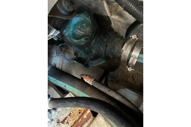 Slide: The Image of Engine compartment of a 2000 Calvin Beal COI PASSENGER boat, showing hoses and metal components. - 75