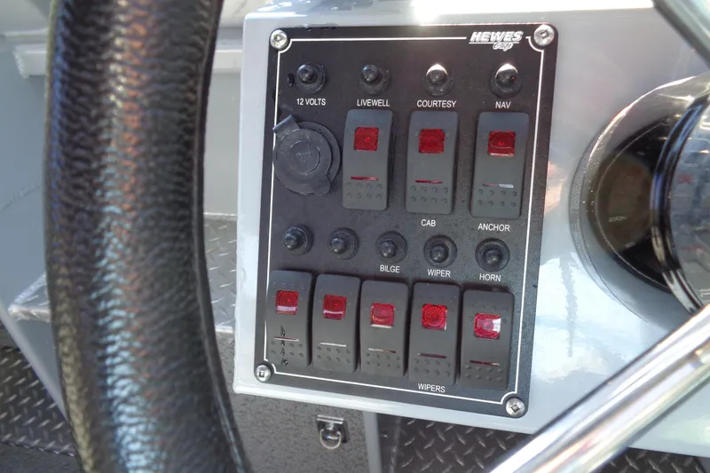 Slide: The Image of Control panel of 2022 Hewes 210 Searunner ET Hardtop boat with various switches. - 12