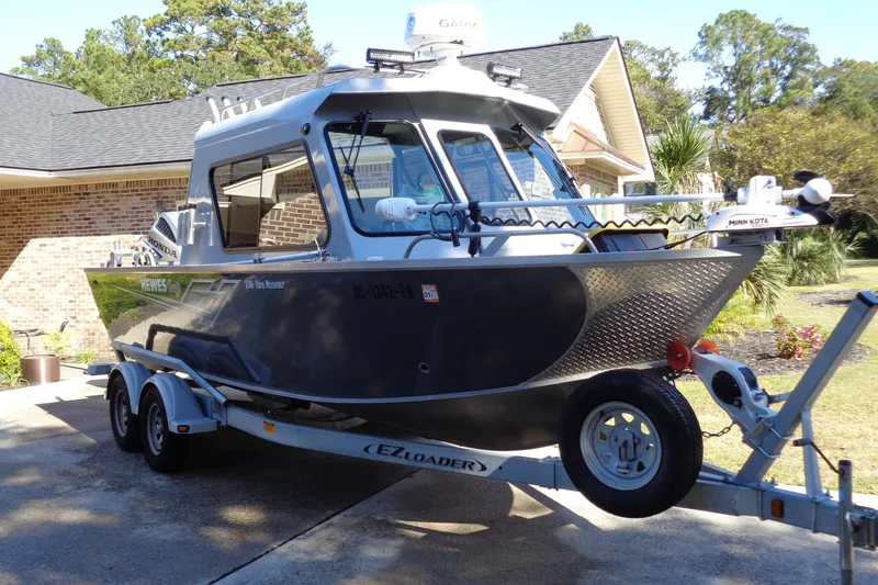 Slide: The Image of 2022 Hewes 210 Searunner ET Hardtop boat on trailer in driveway. - 2