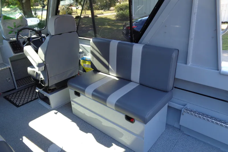 Slide: The Image of Interior of 2022 Hewes 210 Searunner ET Hardtop, featuring gray seating and steering area. - 24