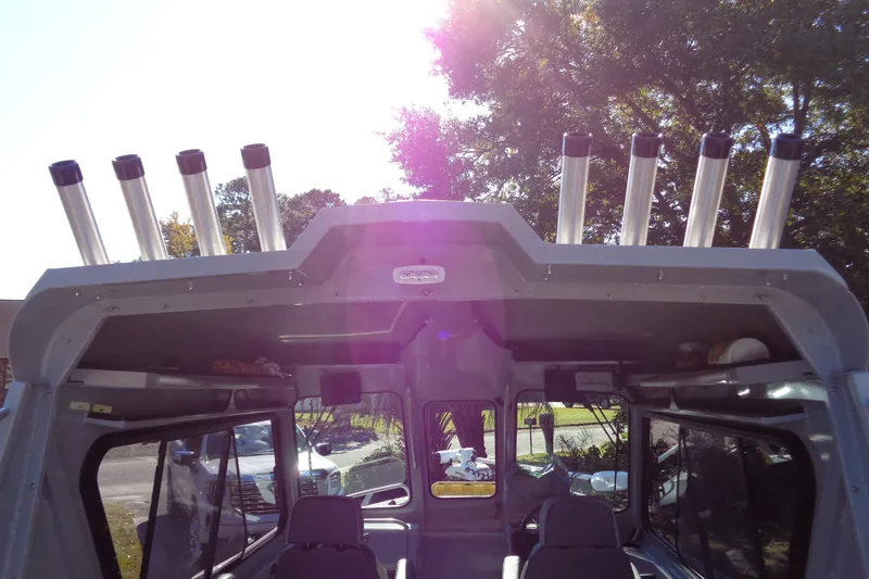 Slide: The Image of 2022 Hewes 210 Searunner ET Hardtop with rod holders, sunlit exterior view. - 26