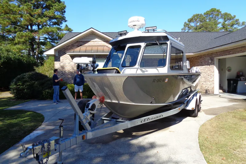 Slide: The Image of 2022 Hewes 210 Searunner ET Hardtop boat on trailer in driveway. - 3
