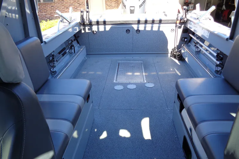 Slide: The Image of Interior of a 2022 Hewes 210 Searunner ET Hardtop boat, featuring seating and storage. - 31