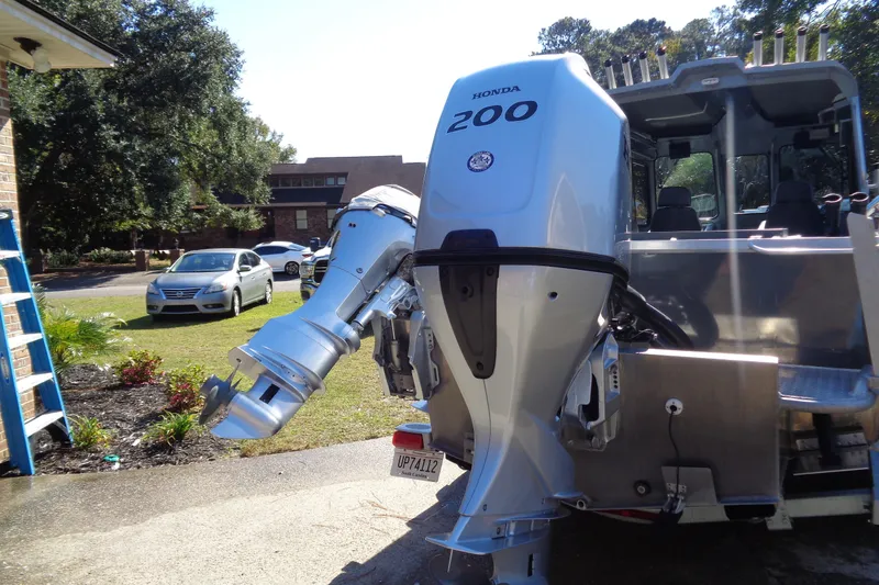 Slide: The Image of 2022 Hewes 210 Searunner ET Hardtop with Honda 200 outboard motor in driveway. - 38