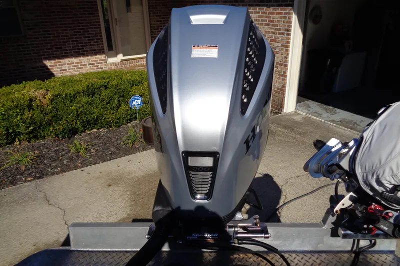 Slide: The Image of Silver outboard motor on a Hewes 210 Searunner ET Hartop, 2022 model, parked in driveway. - 6