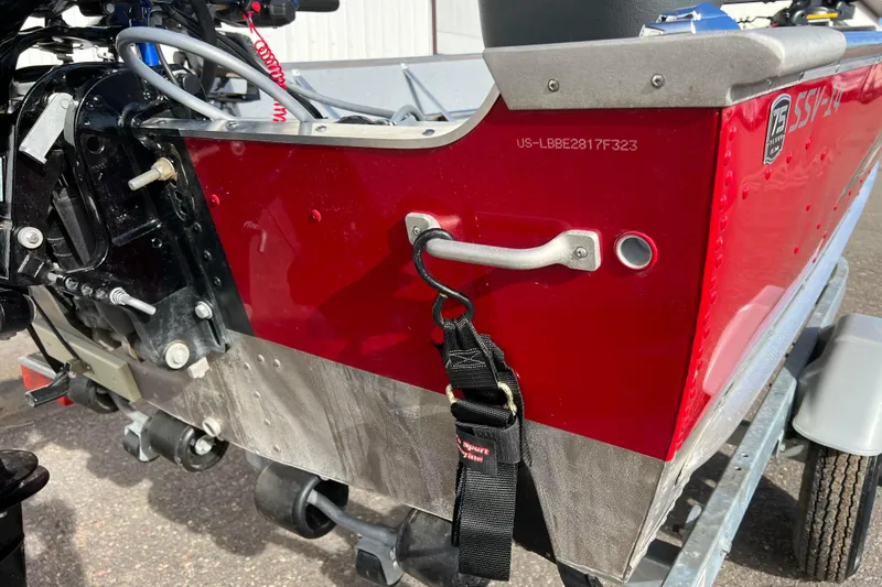 Slide: The Image of 2023 Lund SSV-14 Tiller boat rear view with motor and safety warnings. - 10