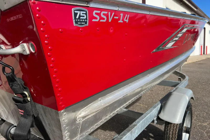 Slide: The Image of 2023 Lund SSV-14 Tiller boat rear view with red exterior and motor details. - 11