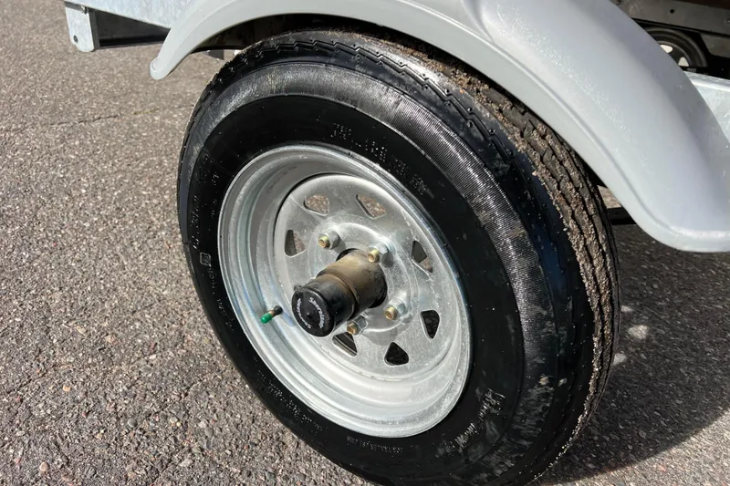 Slide: The Image of 2023 Lund SSV-14 Tiller boat, red exterior, on a trailer, celebrating 75 years. - 12