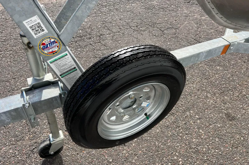 Slide: The Image of 2023 Lund SSV-14 Tiller boat with red and silver hull on trailer. - 15