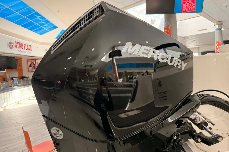 Slide: The Image of 2026 Bayliner Trophy T22SC with Mercury outboard engine in showroom setting. - 19