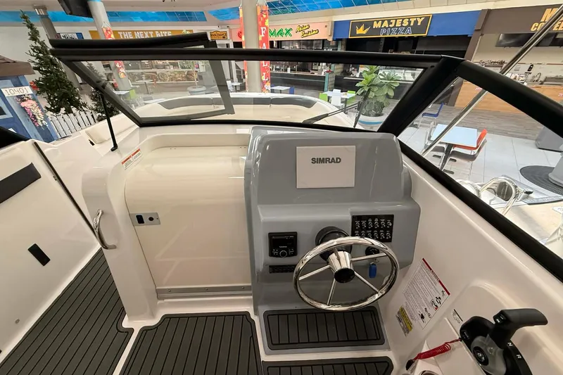 Slide: The Image of 2026 Bayliner Trophy T22SC boat dashboard with steering wheel and Simrad display. - 8