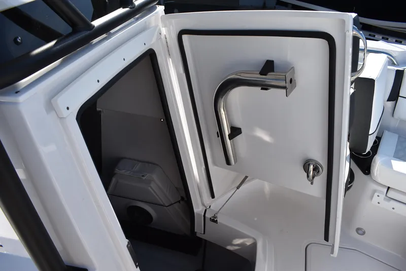 Slide: The Image of 2025 Blackfin 222CC boat interior storage compartment with open door and stainless steel handle. - 17