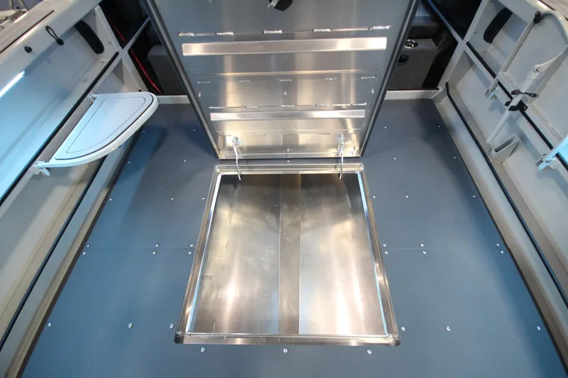 Slide: The Image of Interior view of 2026 Weldcraft 260 Ocean King boat, featuring storage compartment and foldable table. - 37