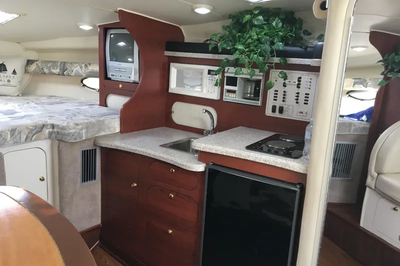 Slide: The Image of 2001 Rinker 310 Fiesta Vee cabin interior with kitchenette and cozy sleeping area. - 5