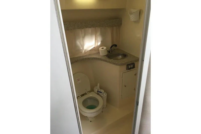 Slide: The Image of 2001 Rinker 310 Fiesta Vee boat bathroom with toilet, sink, and countertop. - 6
